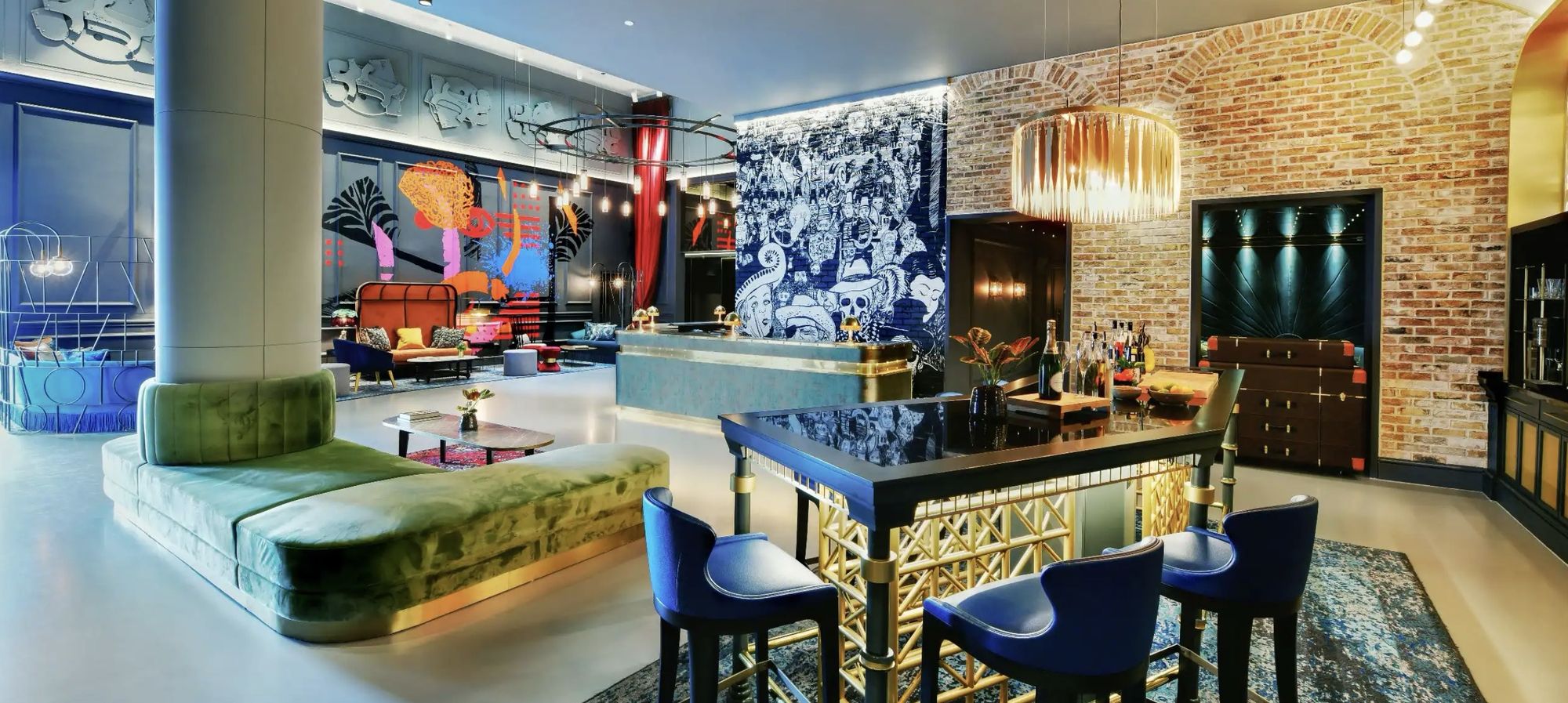 A lounge with velvet seating, artwork, and exposed brick