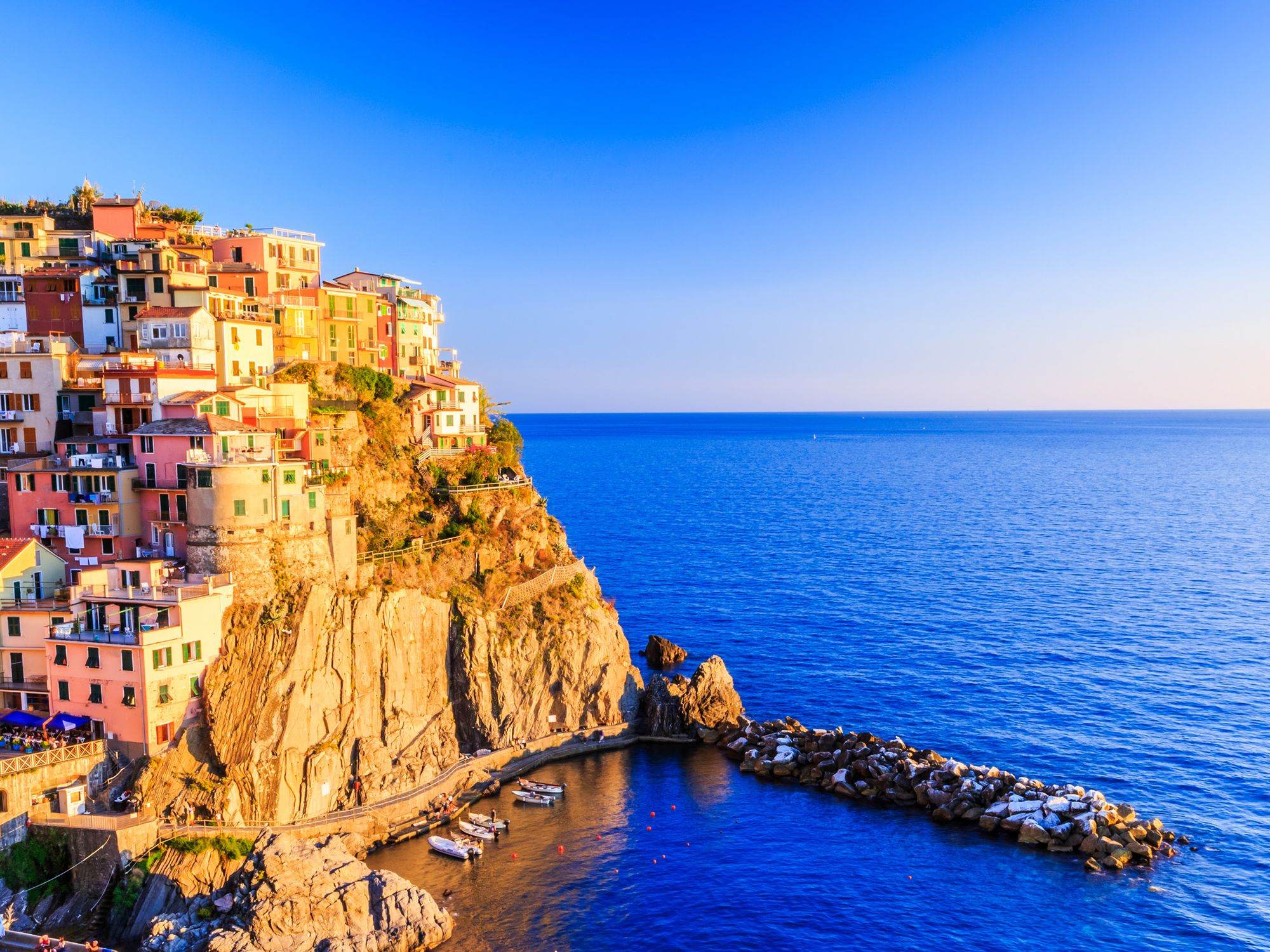 Colorful houses of Cinque Terre stacked on a cliff above a deep blue sea