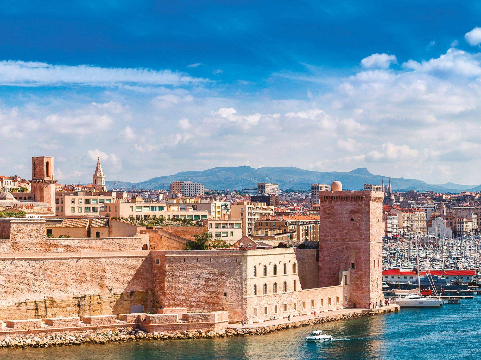 The old port of Marseille, with its fort and harbor under a bright sky