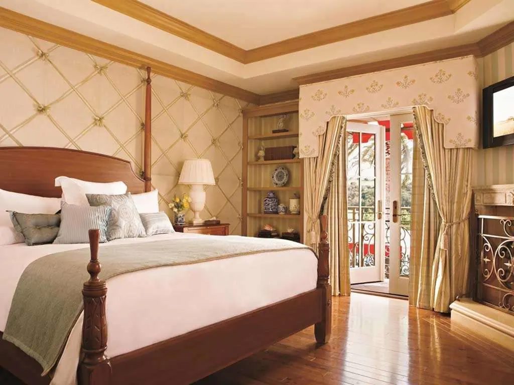 A guest room with a four-poster bed and French doors to a balcony