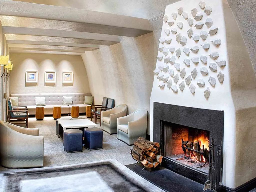 A spa lounge with a white plaster fireplace and soft seating