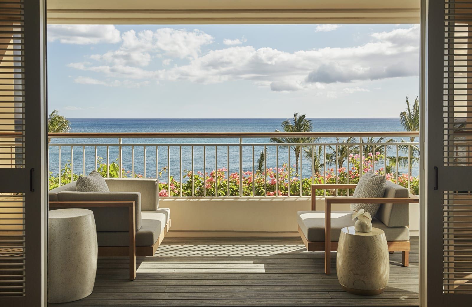 A suite balcony with armchairs facing the Pacific