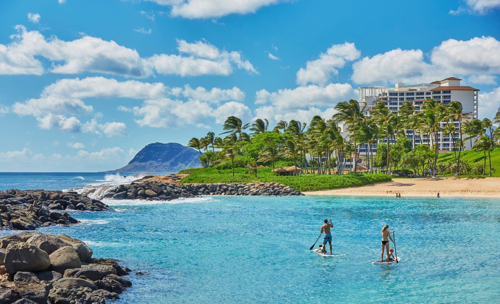 Paddleboarders gliding across a turquoise lagoon