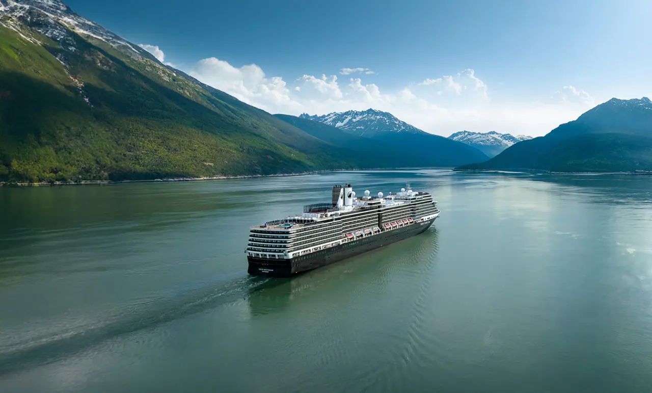 Nieuw Amsterdam cruising a calm Alaska fjord between snowy peaks