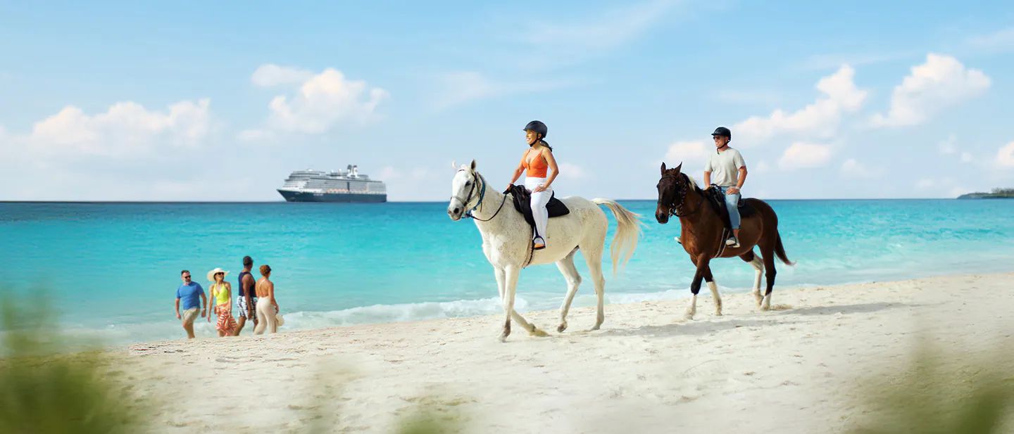 Riders on horseback along the beach at Half Moon Cay, with the ship offshore