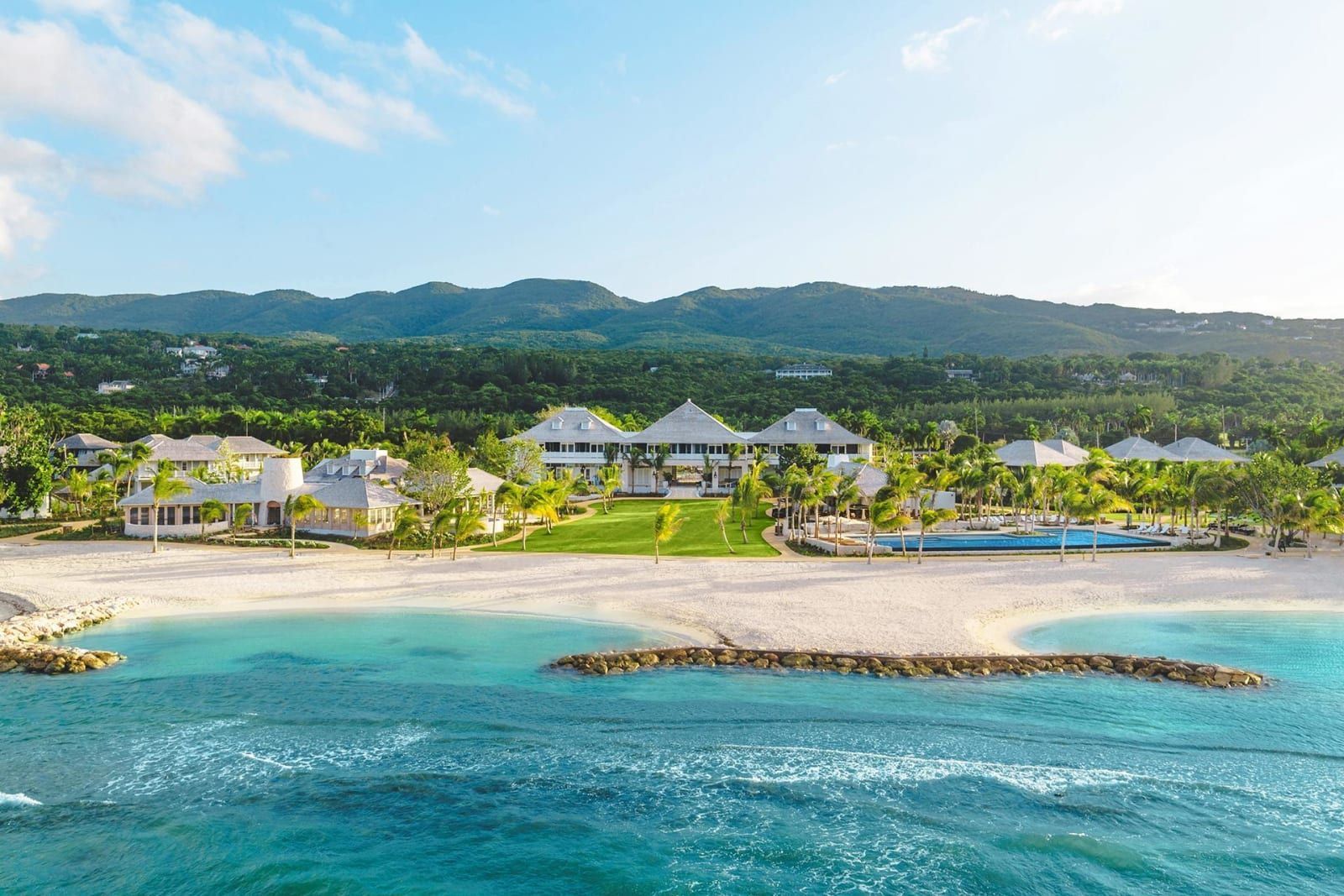 The crescent beach and turquoise bay at Half Moon, with the resort and green hills behind