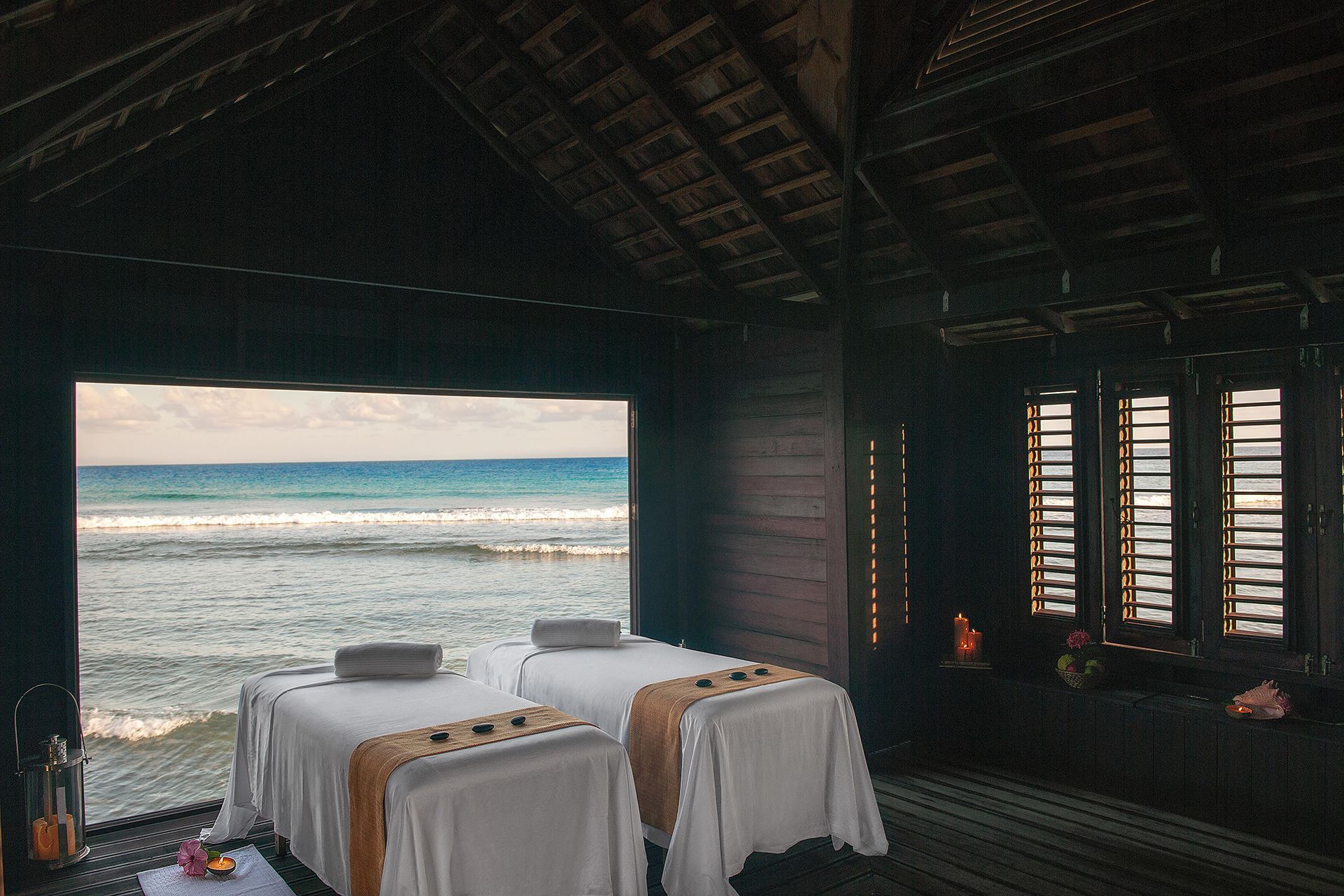 Two treatment tables facing an open window onto the waves