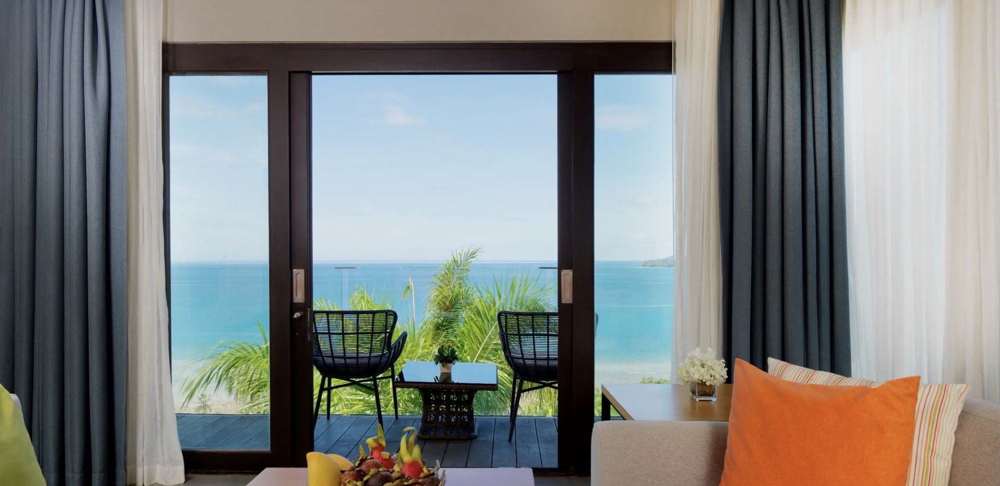A balcony with two chairs looking out to the sea