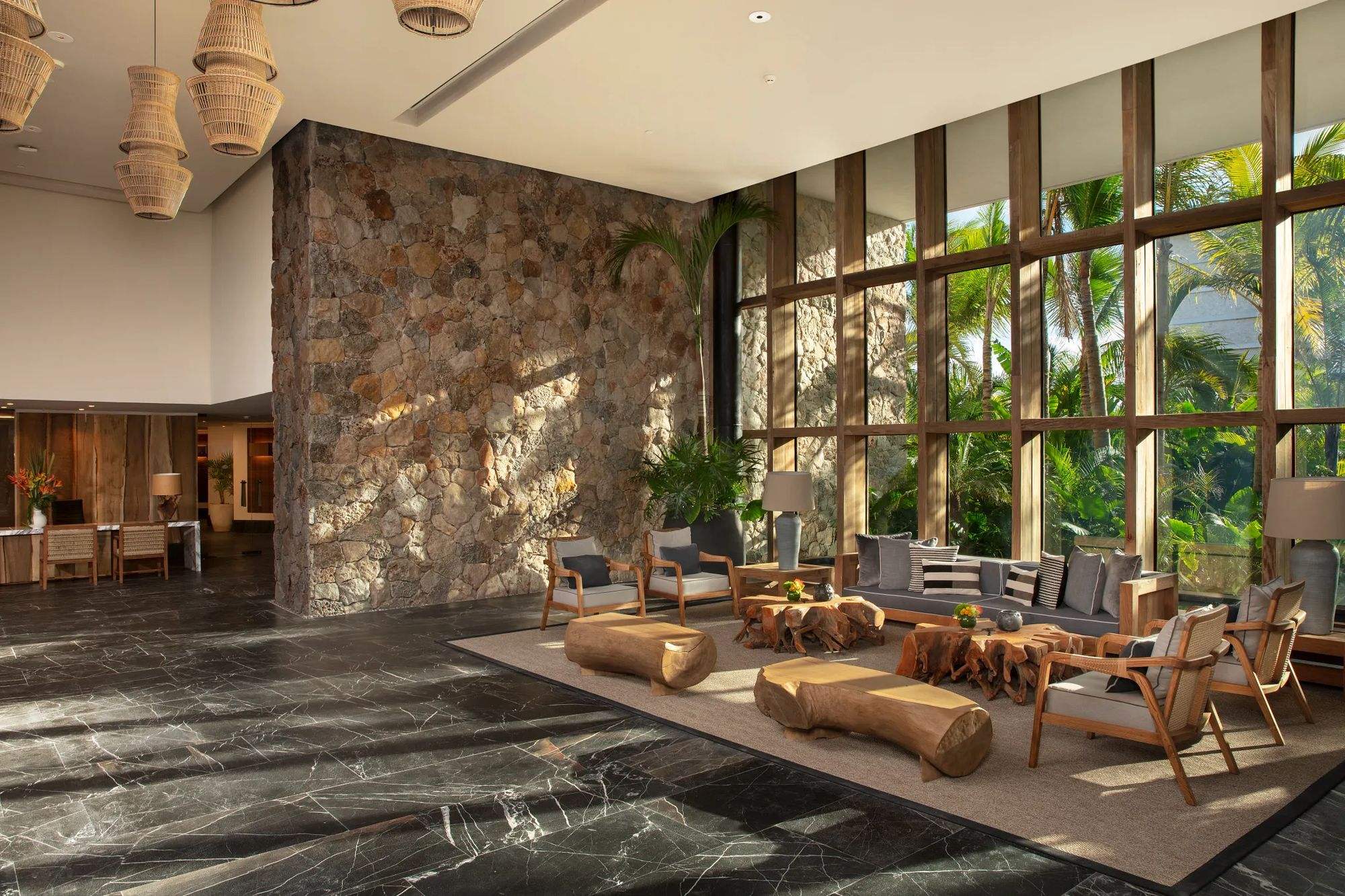 The lobby, with a stone wall and tall windows onto the jungle