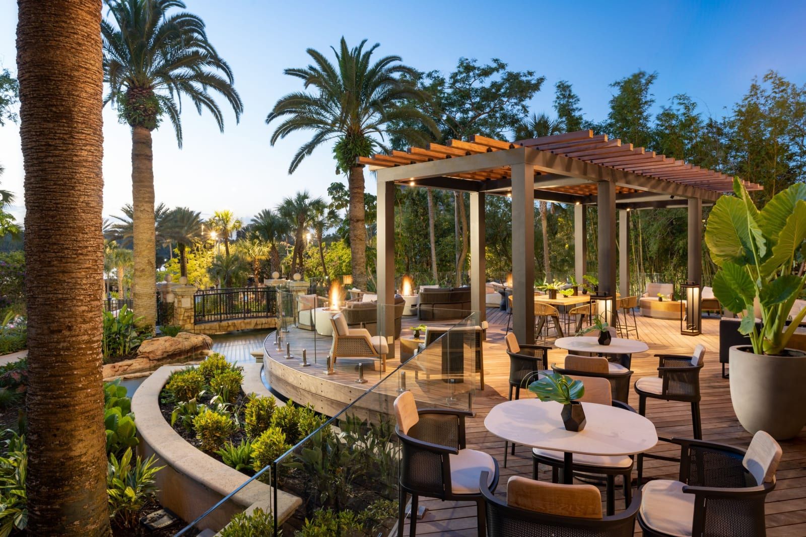 An outdoor terrace bar under a pergola and palms