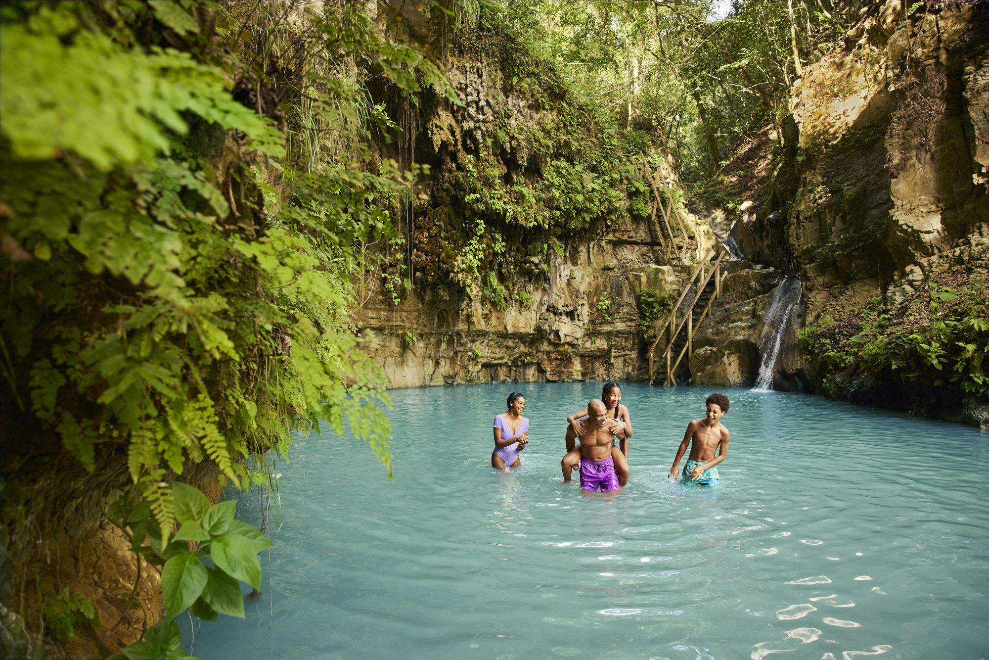 A family swimming in a jungle pool on a shore day in Puerto Plata