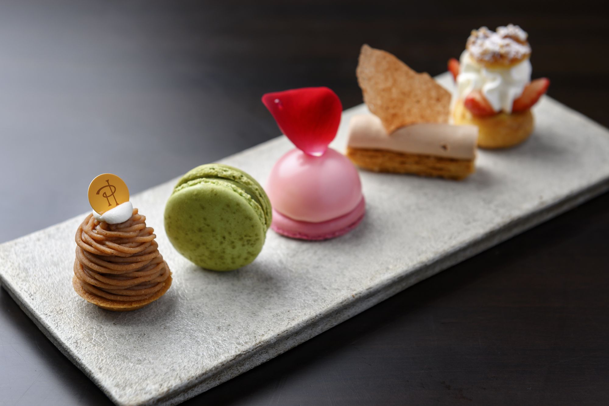 Pierre Hermé macarons and pastries on a slate plate