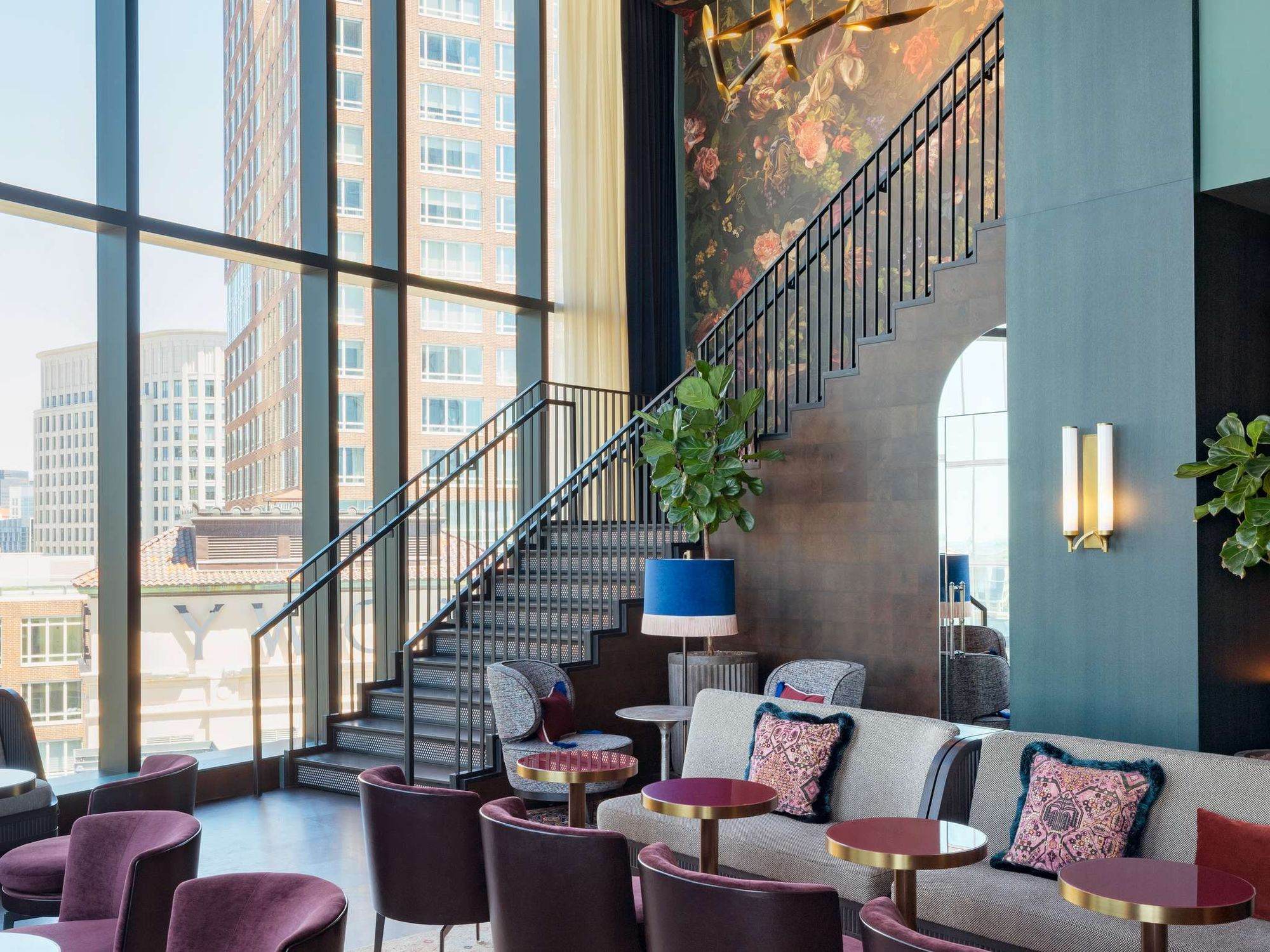 A spiral staircase rising through a lounge with skyline views
