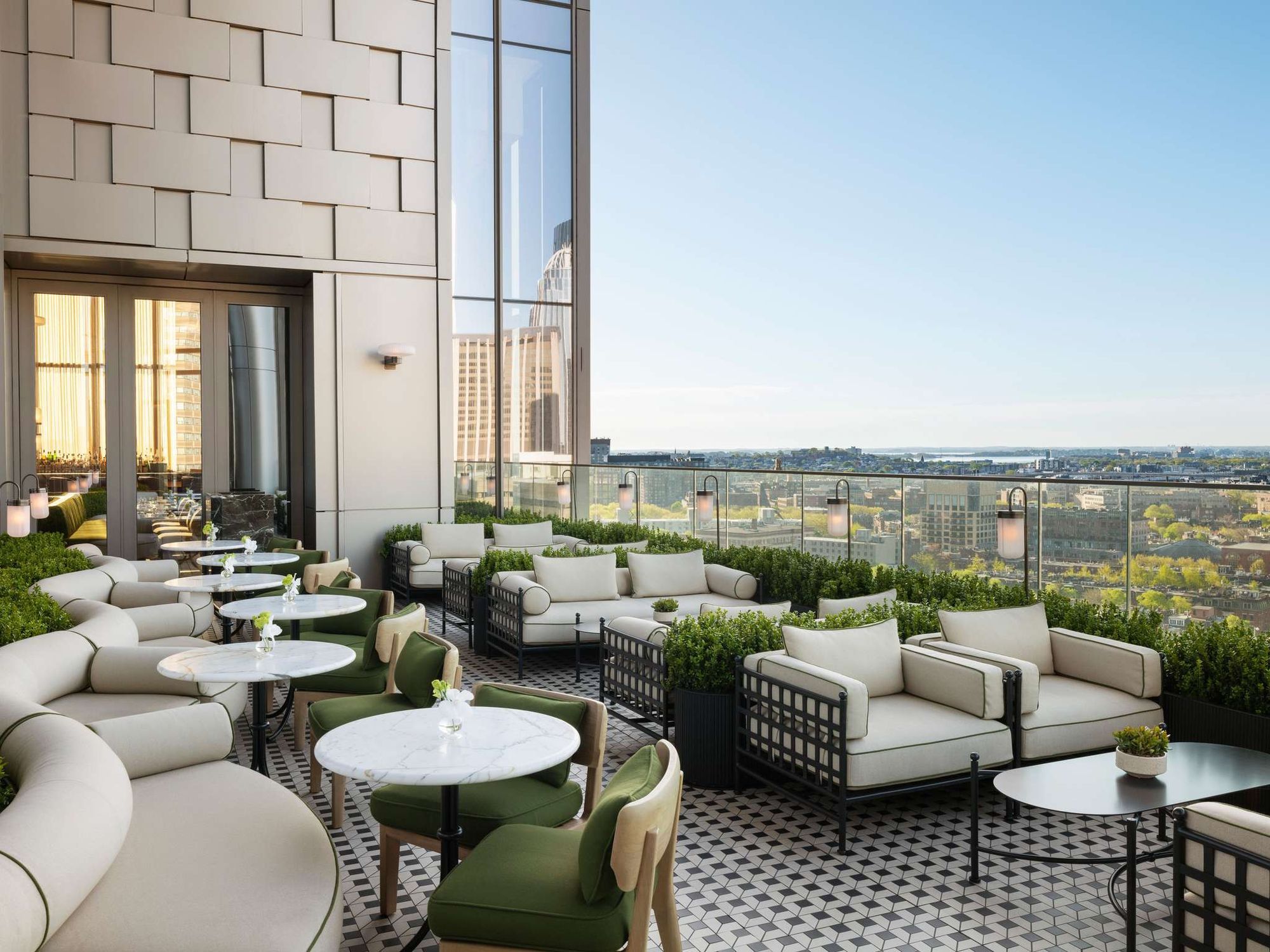A rooftop terrace with garden seating and city views