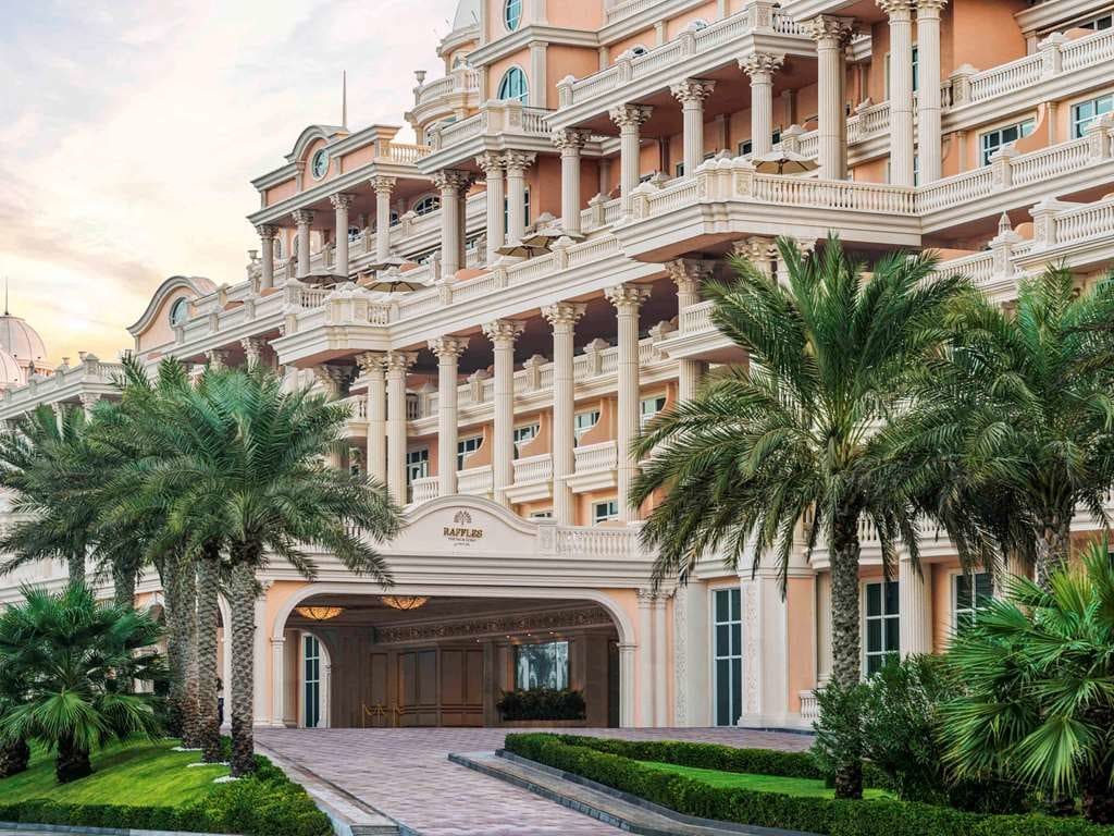 The resort's arched entrance beneath tiers of balconies and palms