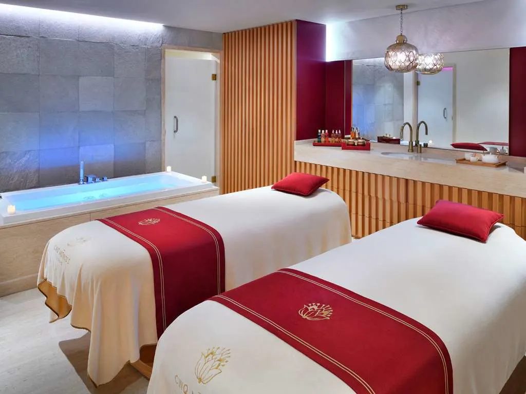 A spa suite with two treatment beds and a soaking tub