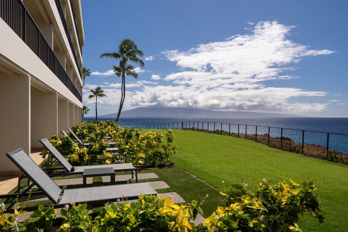 Loungers on a grassy lanai above the ocean