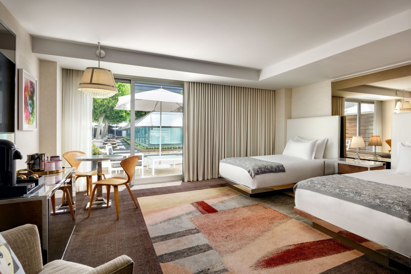A room with two beds opening onto a terrace