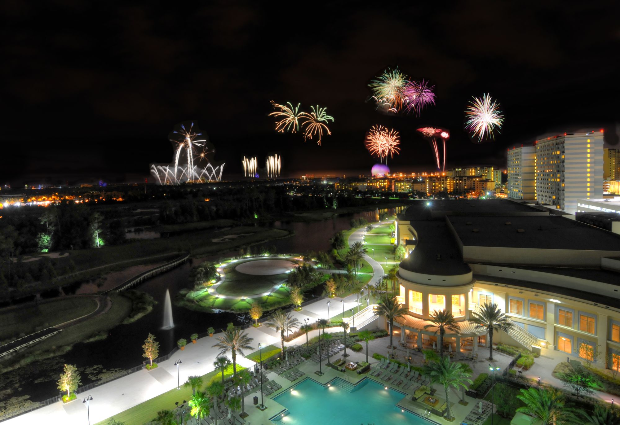 Fireworks over the Orlando skyline, seen from above the hotel's lit pool